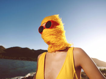 Rear view of woman standing against sky during sunset