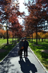 People walking on footpath in park during autumn