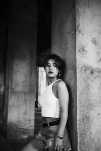 Portrait of woman standing against wall