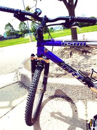 Close-up of bicycle by tree against sky