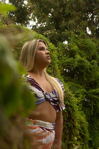 Woman standing by tree in forest