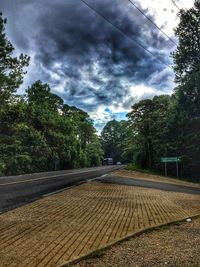 Road by trees against sky