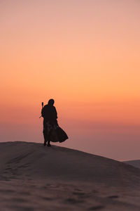 Silhouette man on beach during sunset