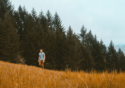 Man standing on land against trees