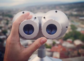 Cropped hand holding coin-operated binoculars