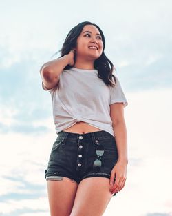 Low angle view of woman standing against sky