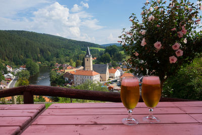 Close-up of beer on table against trees