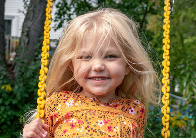 Portrait of smiling girl on swing