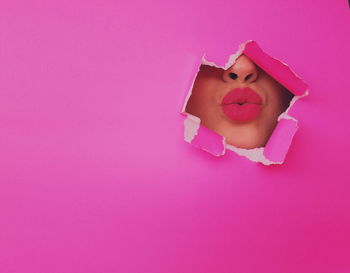 Close-up portrait of woman with pink petals on background