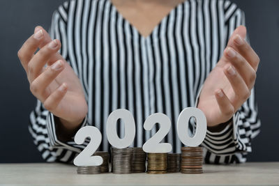Midsection of person holding paper with text on table