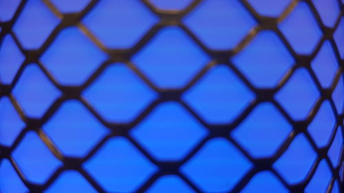 Full frame shot of metal fence against blue sky