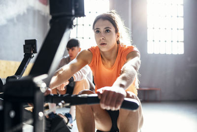 Young man and woman exercising at gym