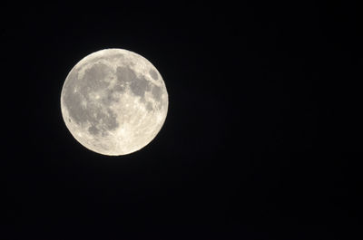 Low angle view of full moon against clear sky at night