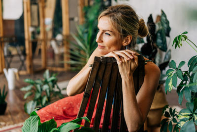 Beautiful satisfied relaxed woman sitting on a wooden chair