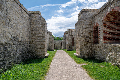 Stone wall of old building against sky