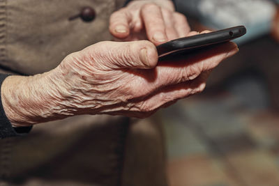 Midsection of man using mobile phone outdoors