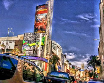 Low angle view of ferris wheel against cloudy sky