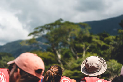 Rear view of people on mountain against sky