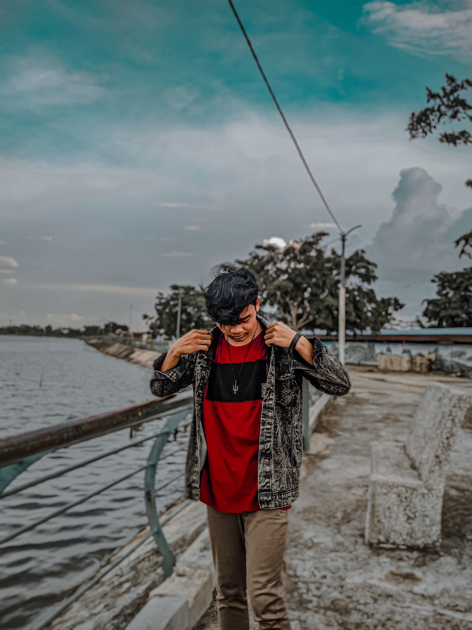 water, cloud, sky, one person, nature, sea, adult, leisure activity, men, activity, standing, full length, front view, lifestyles, holiday, vacation, clothing, land, trip, young adult, casual clothing, outdoors, beach, fishing, rope, day, travel, beauty in nature, holding, fishing rod, person, adventure, scenics - nature, motion, travel destinations