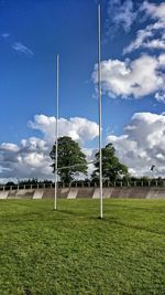 Trees on field against cloudy sky