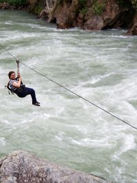 High angle view of woman zip lining over river