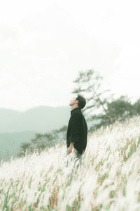 Man standing on field against sky