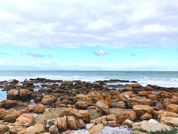 Rocks by sea against sky