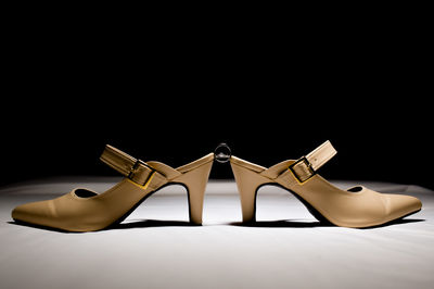 Close-up of shoes on table against black background