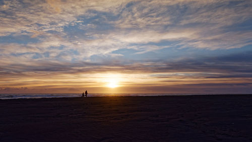 Scenic view of beach against sky during sunset