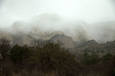 Scenic view of mountains against sky during foggy weather