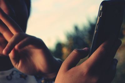 Cropped image of woman using mobile phone