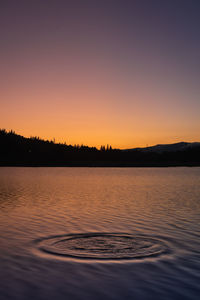 Scenic view of lake against orange sky