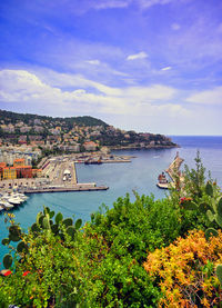 Scenic view of sea and townscape against sky