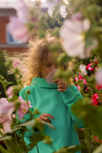 Woman with pink flowers on plant