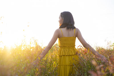 Woman standing on field against sky