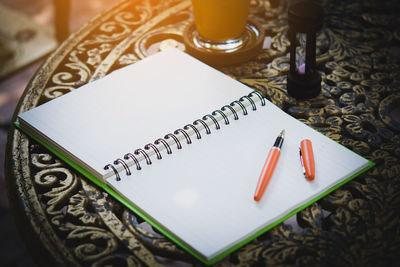 High angle view of notebook and pencil on table