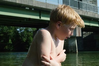 Close-up of cute boy shivering while standing in lake