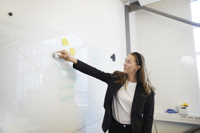 View of woman cleaning whiteboard