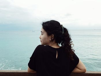 Rear view of woman standing against sea