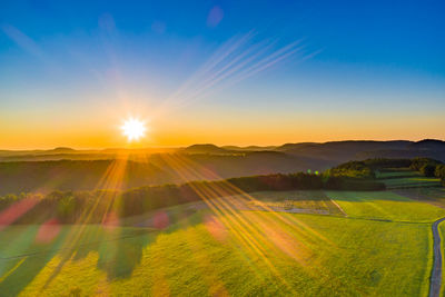 Scenic view of field against sky during sunset