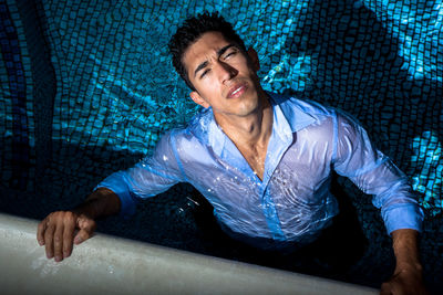 High angle portrait of young man swimming in pool