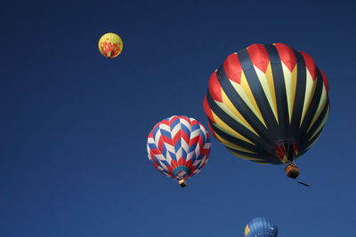 Low angle view of hot air balloons against blue sky