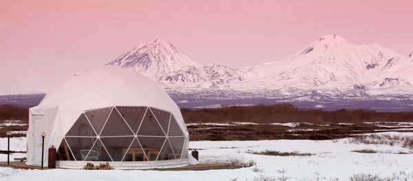 Glamping house and volcano, rural landscape, tent houses in kamchatka peninsula. selective focus.