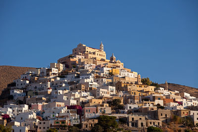 Buildings in city against clear blue sky