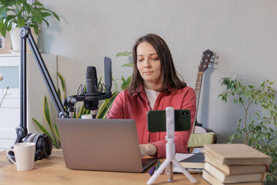 Portrait of young woman using laptop at home