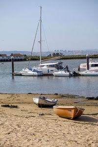 Boats moored on shore against clear sky