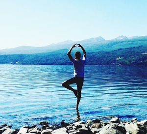 Full length of young woman in lake against clear sky