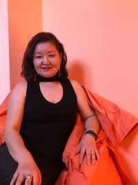 Portrait of smiling young woman sitting at home