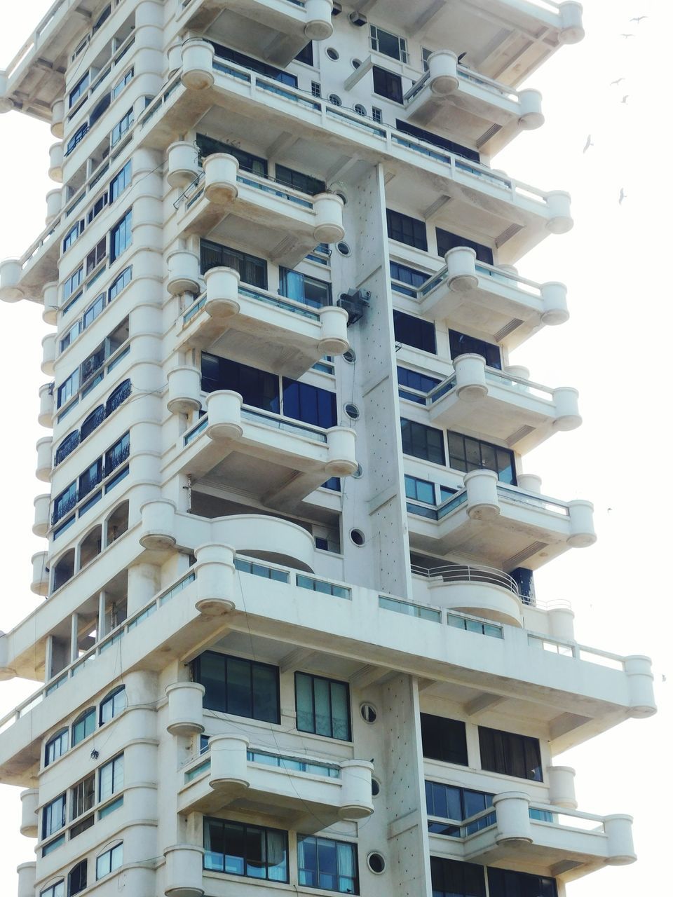 building exterior, architecture, built structure, low angle view, building, balcony, window, in a row, residential building, residential structure, city, repetition, apartment, day, modern, outdoors, no people, sky, clear sky, city life