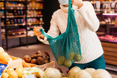 Midsection of woman holding ice cream at store